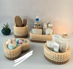 three baskets with soaps, toothbrushes and other personal care items in them