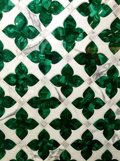 the green and white tiles are arranged in an intricate pattern, which is made up of overlapping shapes