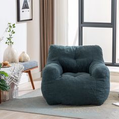 a blue bean bag chair sitting on top of a rug in front of a window