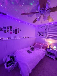 a bedroom with purple lights and a bed in the middle is lit by a ceiling fan