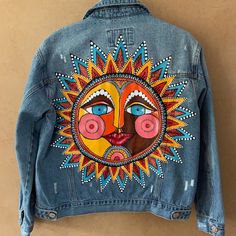 Beautiful Hand Painted Denim Jacket Of The Mexican Sun. Very Detail Oriented, Took A Long Time To Paint. Unique And One Of A Kind. Details Include: - Hand Sewn Beading On The Pocket - Distressed Denim Care Instructions: Has Already Been Heat Set And Can Be Washed. Wash Inside Out With Cold Water On A Gentle Setting And Let It Air Dry. Do Not Put The Jacket Into The Dryer. Measurements With Jacket Laid Flat: Chest: 20” Shoulder Length: 6” Arm Length: 21.5” Hem Width: 20” Overall Length: 22.5” Hand Painted Jean Jacket, Wrestling Clothes, Painted Leather Jacket, Custom Jean Jacket, Personalized Jacket, Hand Painted Denim Jacket, Painted Denim Jacket, Painted Jacket, Painted Jeans