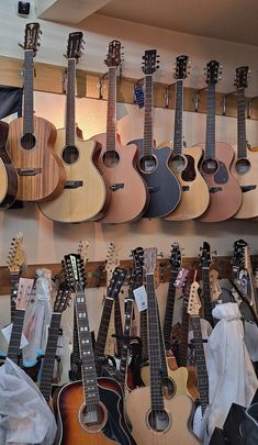 several guitars are hanging up on the wall