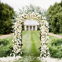 an outdoor wedding ceremony with white flowers and greenery