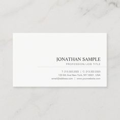 a white business card sitting on top of a marble surface with the word, photographer