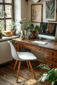 a desk with a computer on it and some plants in the window sill next to it