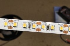 a close up view of the back side of a white led strip with yellow lights