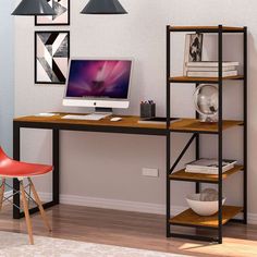 a desk with a computer on top of it in front of two pictures and a chair