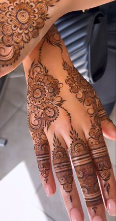 two hands with henna tattoos on them