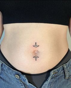 a woman's stomach with an arrow tattoo on her lower belly and the bottom part of her abdomen