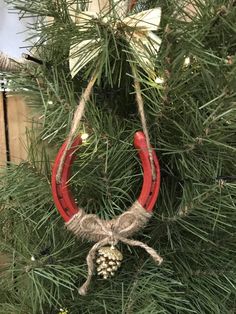 a christmas ornament hanging from a tree with pine cones and twine on it