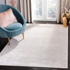 a blue chair sitting on top of a wooden floor next to a white area rug