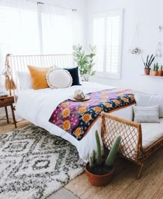 a bedroom with white walls and plants on the bed