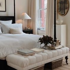 a white bed sitting next to a window in a bedroom