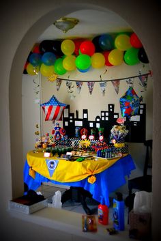 a birthday party with balloons and decorations on the wall, including a table covered in candy