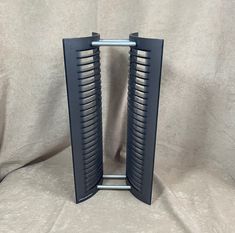 a pair of black and silver speakers sitting on top of a white cloth covered floor