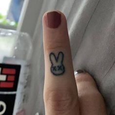 a person's finger with a small tattoo on it