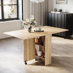 a wooden table sitting in front of a window next to a vase filled with flowers