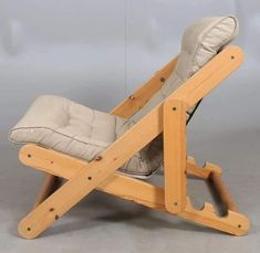 a chair made out of wood with a cushion on it's back and legs