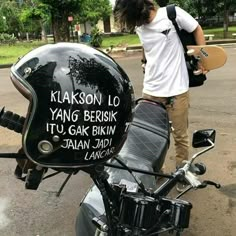 a man standing next to a parked motorcycle with a helmet on it's back