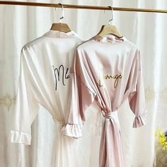 two robes with writing on them hanging from a rack