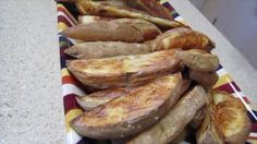 some potatoes are sitting on a colorful striped plate and ready to be cooked in the oven