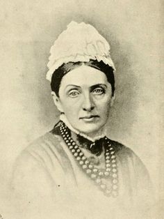 an old black and white photo of a woman wearing a headdress with pearls