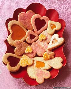 heart shaped cookies in a red bowl on a pink tablecloth with flowers and hearts