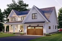 a two story white house with brown garage doors