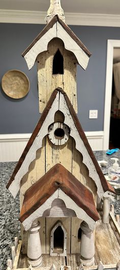 a bird house made out of wood on top of a table