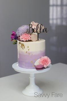 there is a cake with flowers on it and the name bella written on top