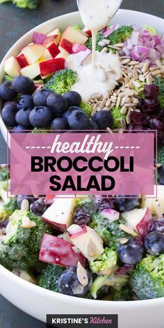 broccoli salad with blueberries, apples and other vegetables in a white bowl