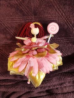 a pink and gold ballerina doll with lollipops