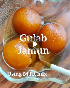 three oranges sitting in a glass bowl on top of a wooden table with the words gulab jamun using mtr mix