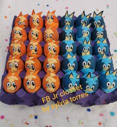 an egg carton filled with blue and orange eggs covered in angry birds'faces