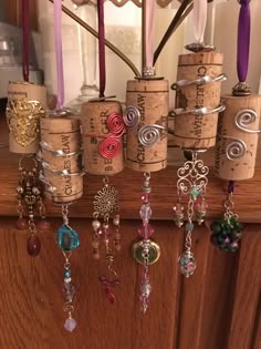 several wine corks are hanging on the wall with beads and charms attached to them