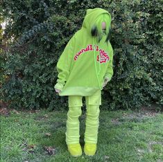 a person in a neon green hoodie and leggings stands on the grass