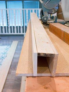 a wooden bench sitting on top of a hard wood floor next to a sawhorse