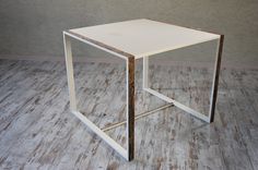 a small white table on a wooden floor