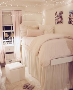 a bedroom with white bedding and lights on the ceiling