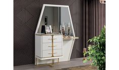 a white and gold dresser with a mirror on it next to a potted plant