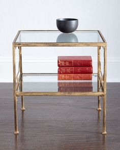 a glass table topped with books and a black bowl sitting on top of each other