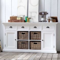 a white sideboard with baskets on it next to stairs