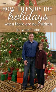 a man and woman standing in front of a christmas tree with the words how to enjoy the holidays when there are no children in your home