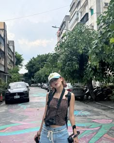 a woman standing in the middle of a street with graffiti all over her body and head