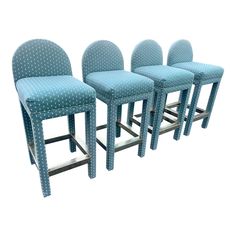 four blue bar stools sitting next to each other in front of a white background