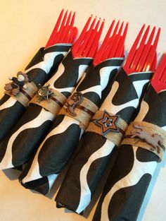 six red and black utensils are lined up in a row on a table