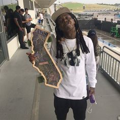 a man with dreadlocks holding a skateboard