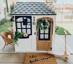a doll house with a welcome mat on the ground