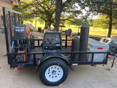 a utility trailer with an air compressor on the front and back wheels is parked in a driveway