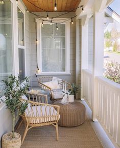 the front porch is decorated with wicker furniture and string lights